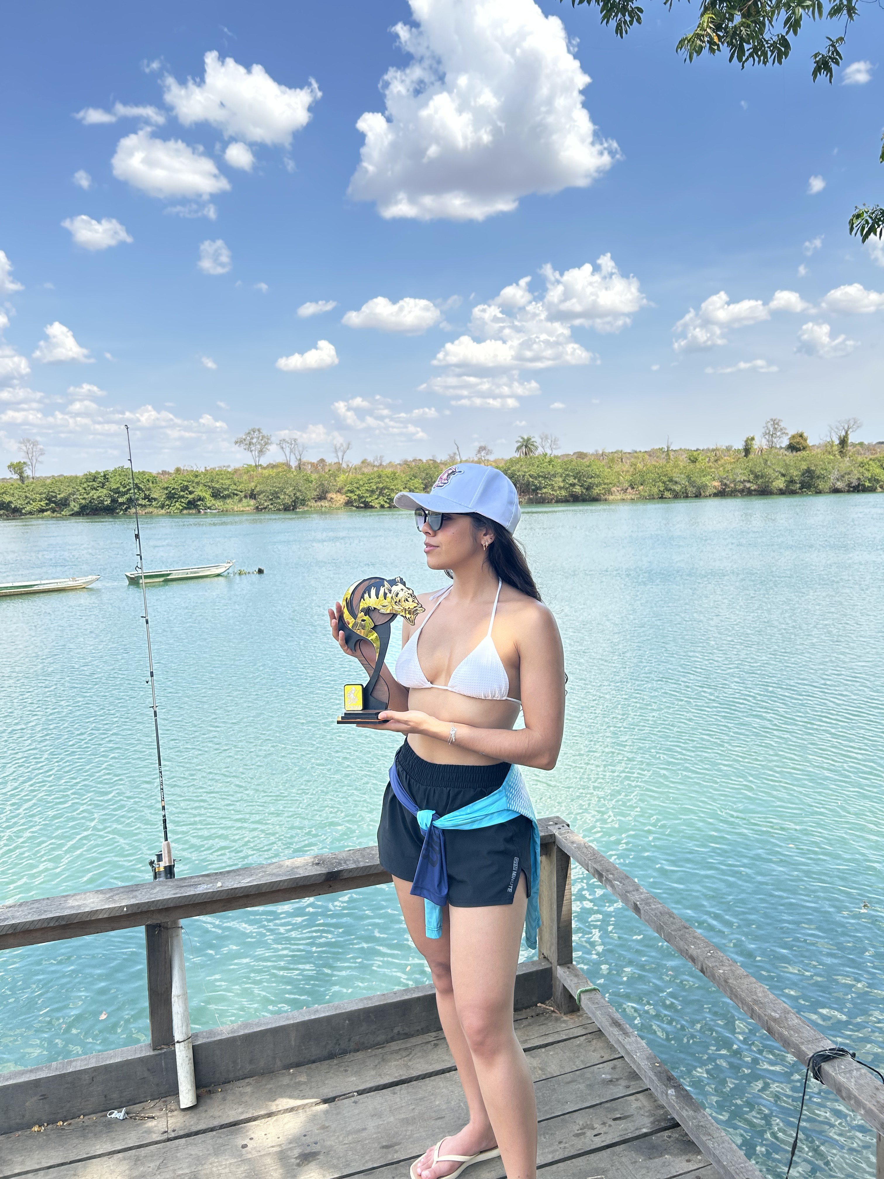 Pescadora com o troféu da premiação no trapiche