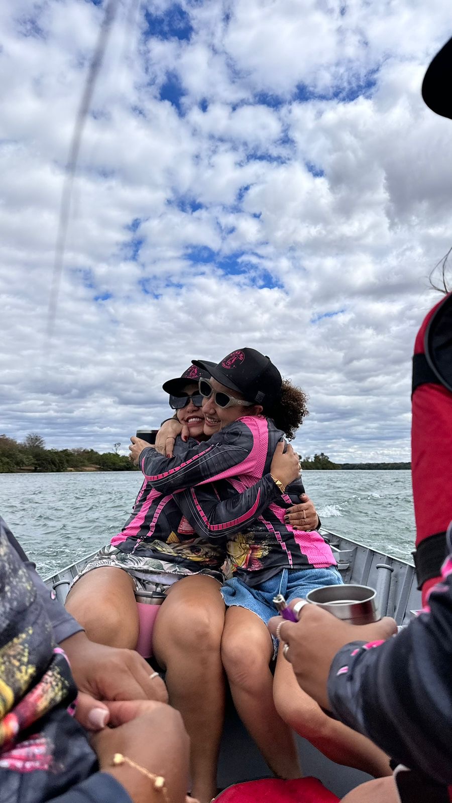 Amigas se abraçando no barco durante a pescaria
